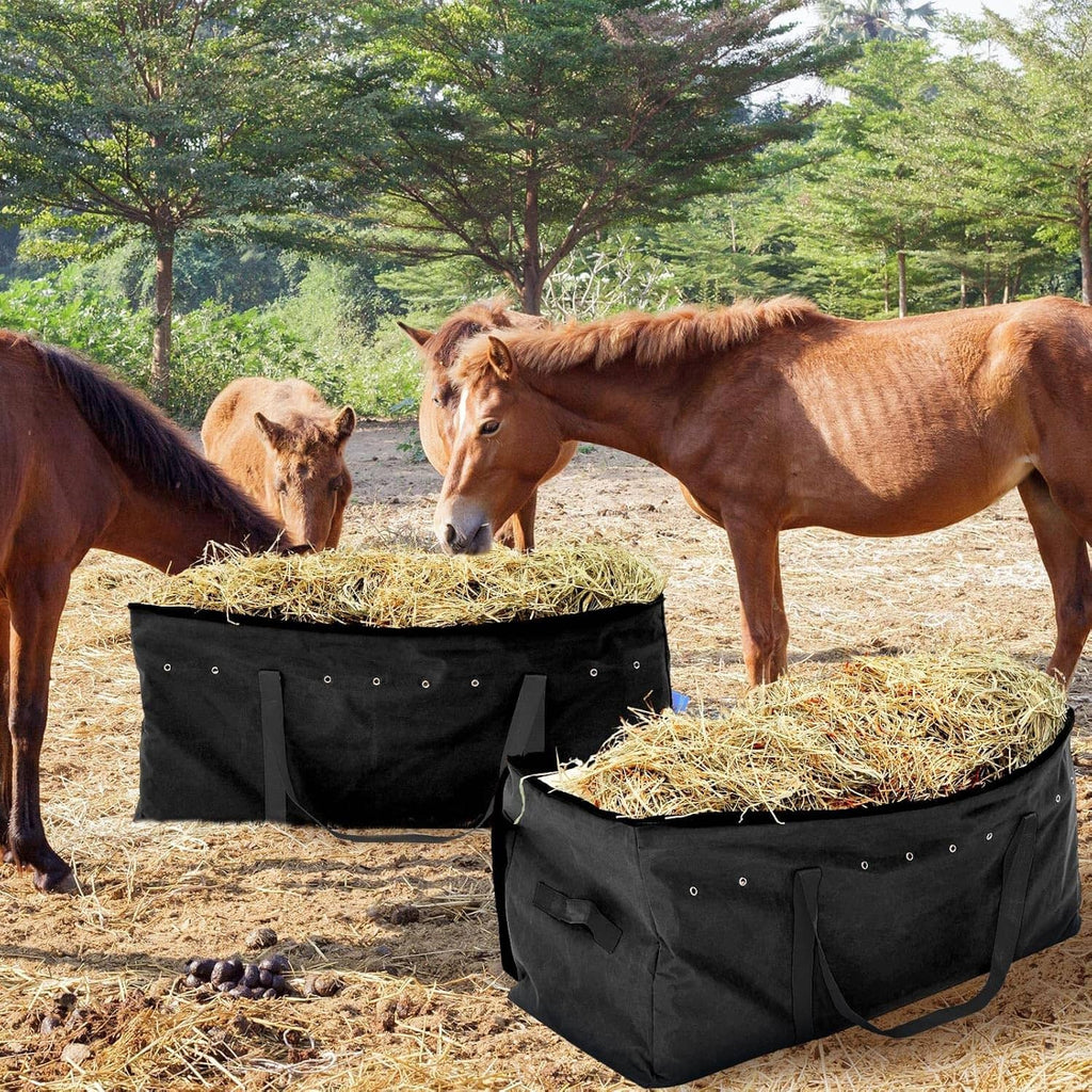Two black hay storage bags filled with hay, each with side carry handles and vent holes
