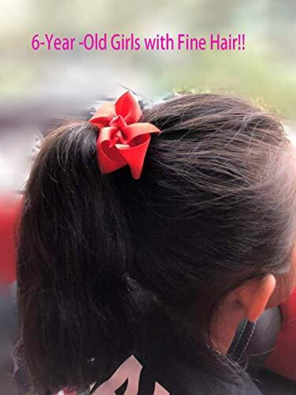 Red pinwheel hair bow clipped on dark hair