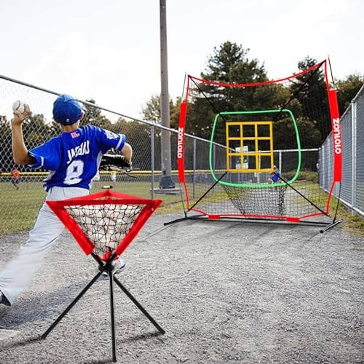 Baseball pitching net with yellow strike-zone grid and red ball caddy for practice