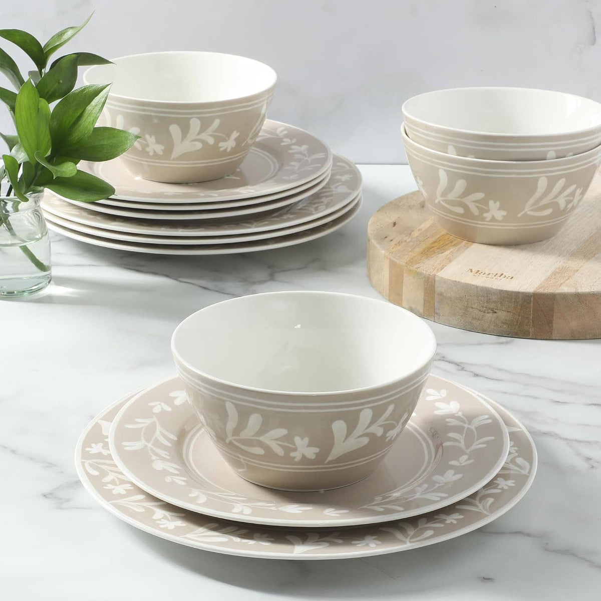 Taupe dinnerware set with white botanical pattern bowls and stacked plates