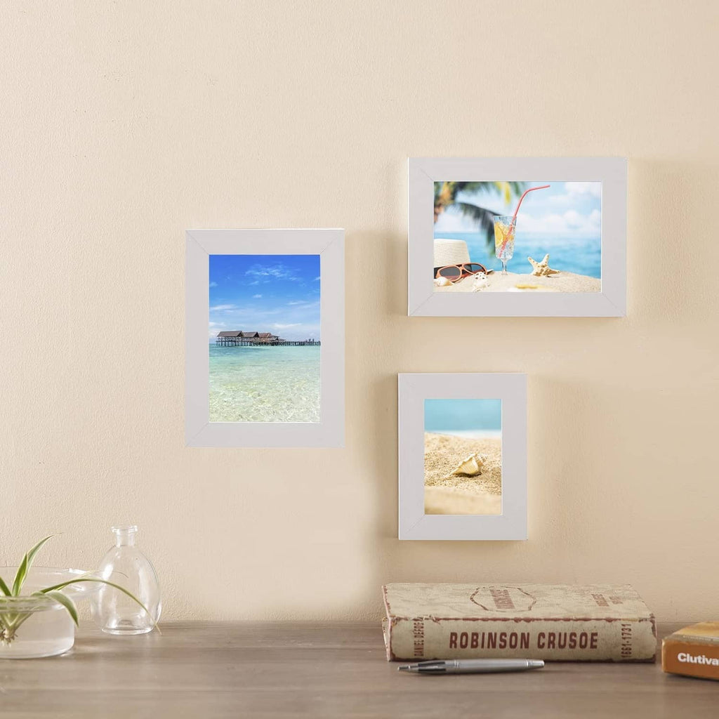 Three small framed landscape photo prints arranged on a table and wall