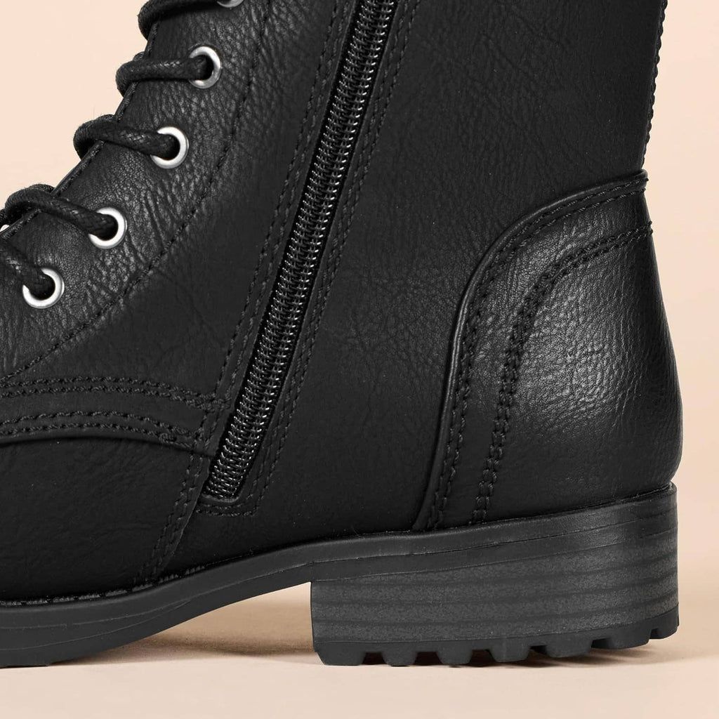 Black combat boot detail: side zipper seam and textured lug sole