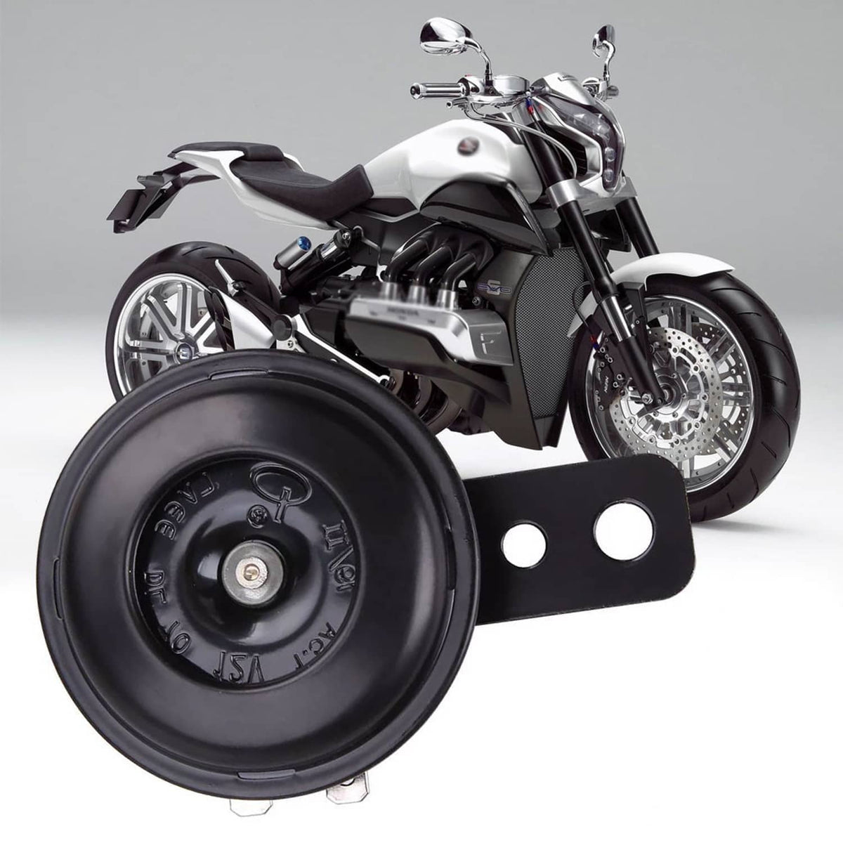 Black electric horn on a motorcycle, circular housing with black bracket and two holes.