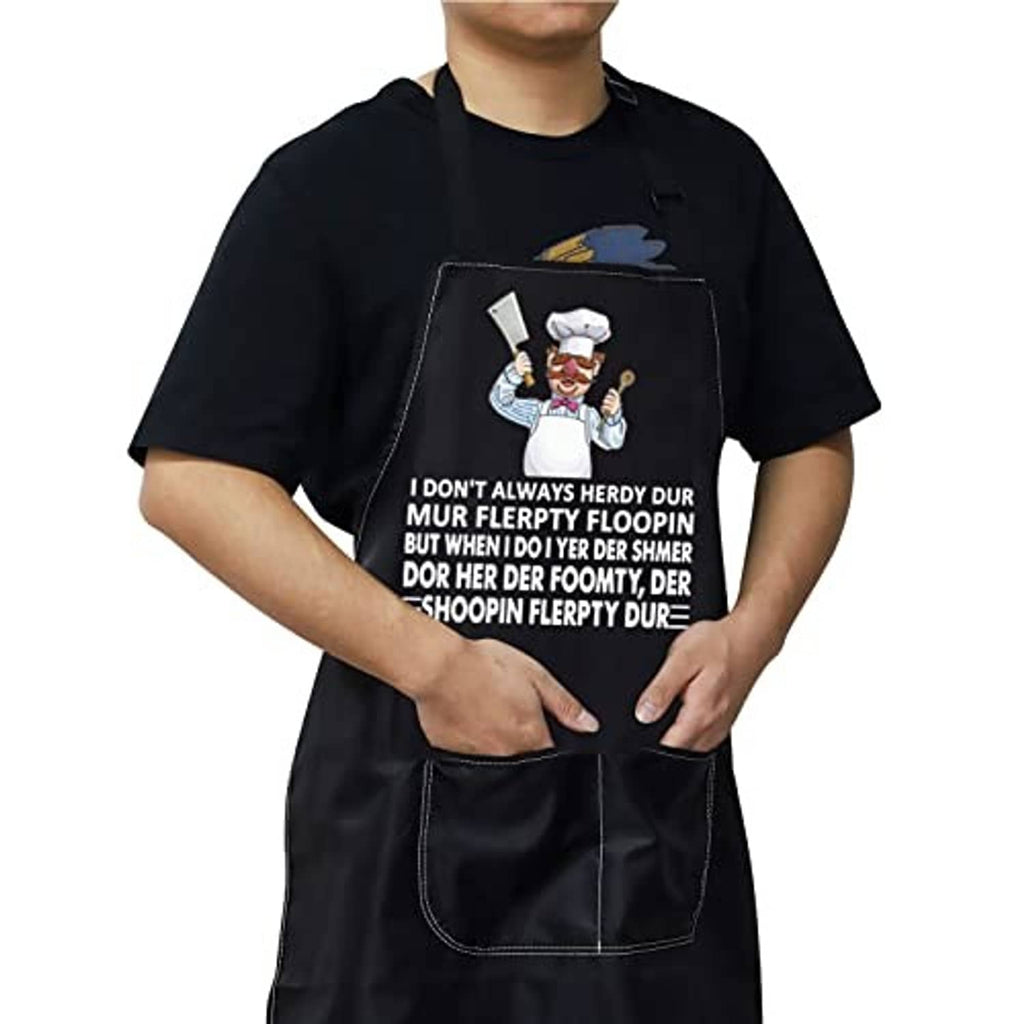 Black kitchen apron on black shirt, chef cartoon emblem and two-pocket front design.