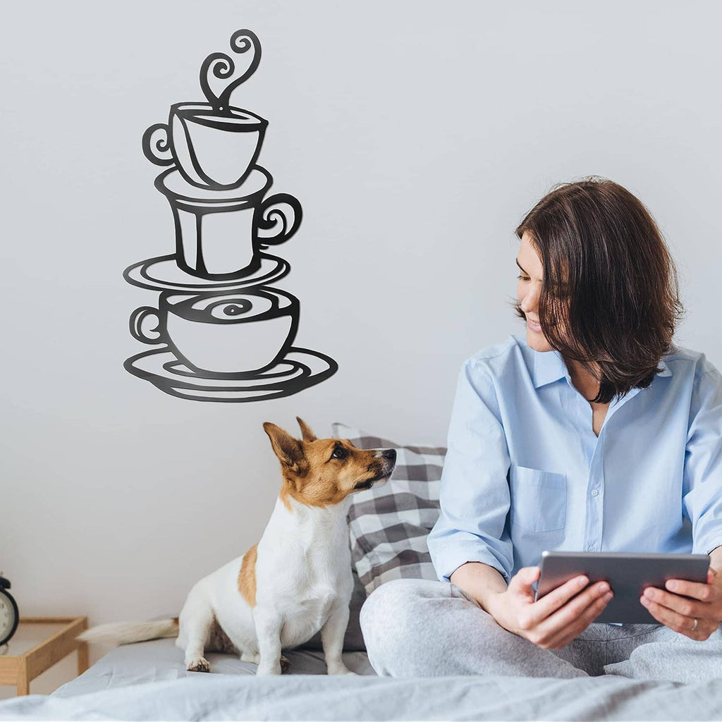 Dark metal coffee cup stack wall art on light wall beside a seated dog and person