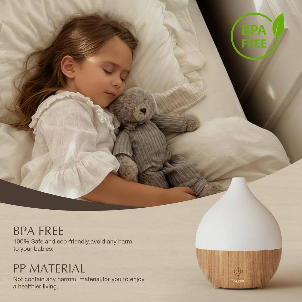 Essential oil diffuser with white cap and wood-grain base on a bed