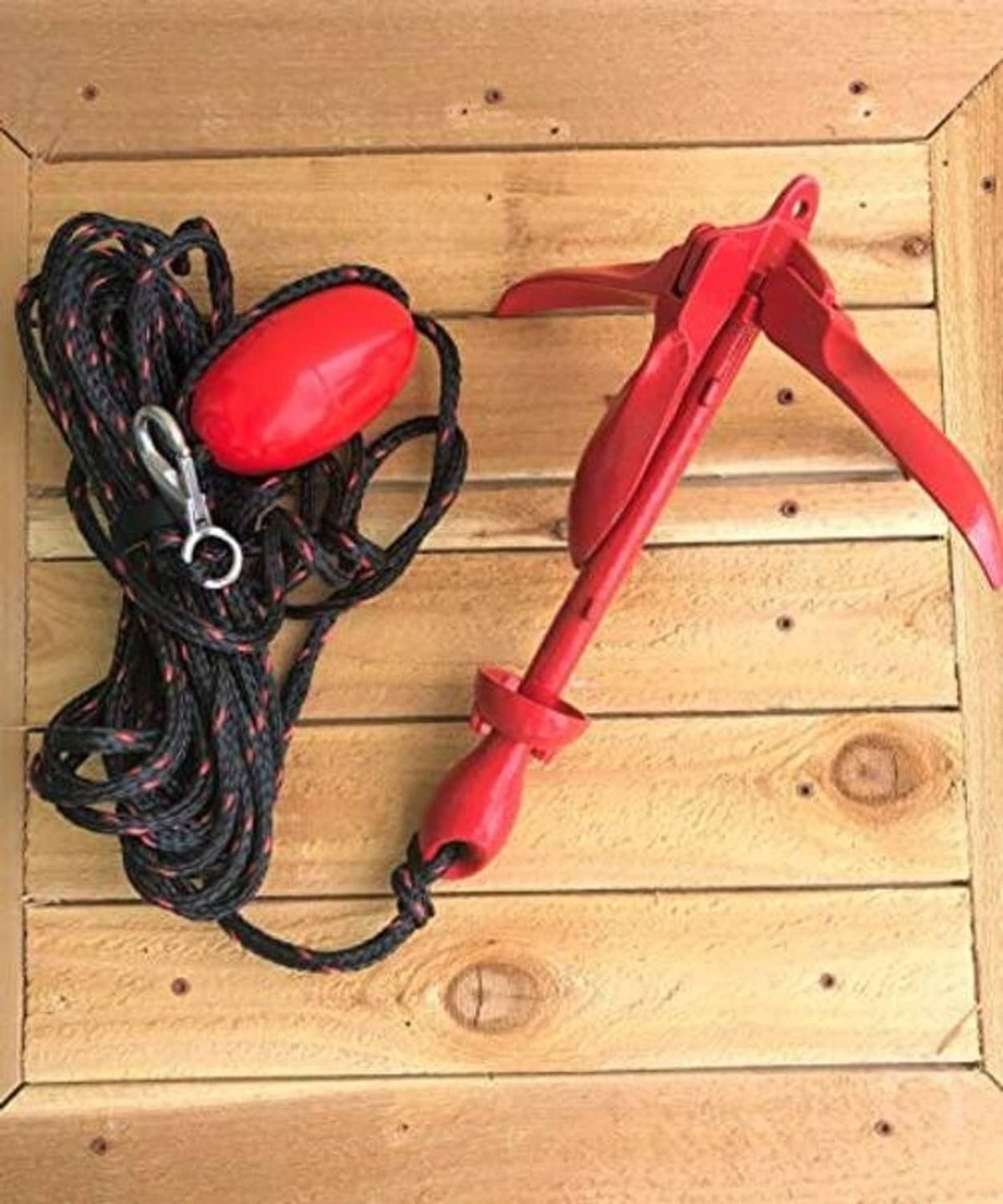 Grapnel anchor kit with red anchor, black rope coil, red float, and snap clips