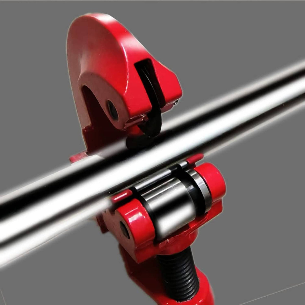 Red golf club shaft cutter with metal rollers positioned on a club shaft