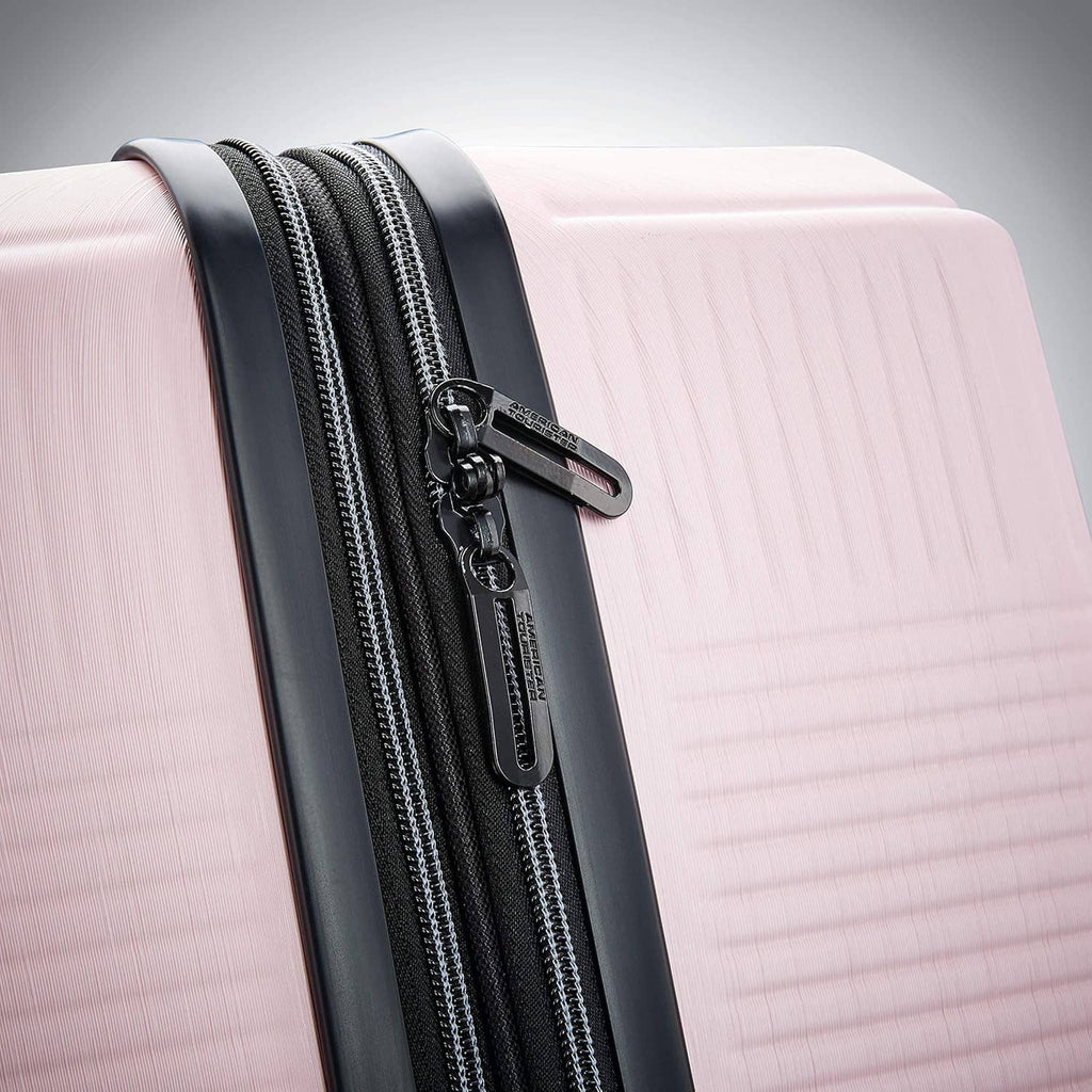 Pink hard-shell luggage close-up of side zipper track with metal zipper pull