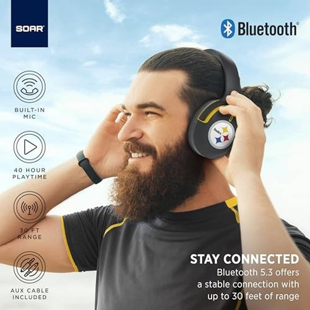 Man wearing dark gray over-ear Bluetooth headphones with Green Bay Packers G logo