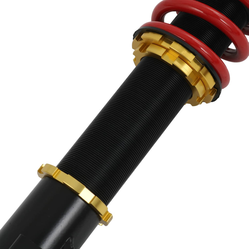 Close-up of coilover strut spring with red coils and black body, gold adjuster ring