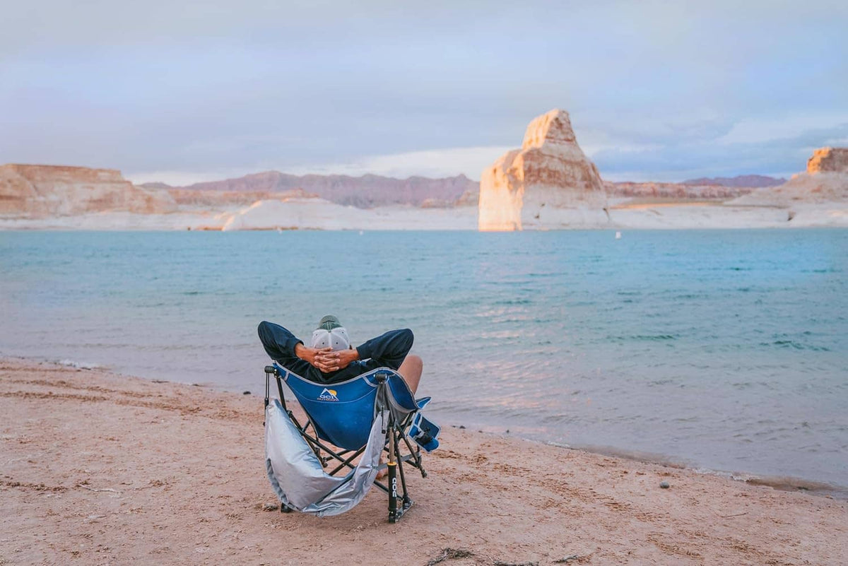 Blue outdoor rocking chair with canopy on beach sand