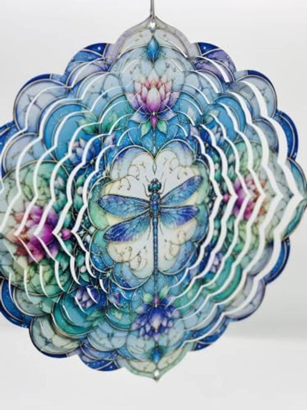 Close-up hanging lotus flower wind spinner with blue dragonfly artwork