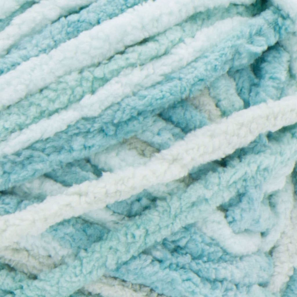 Close-up of super bulky chenille-style yarn with light blue and pale green stripes