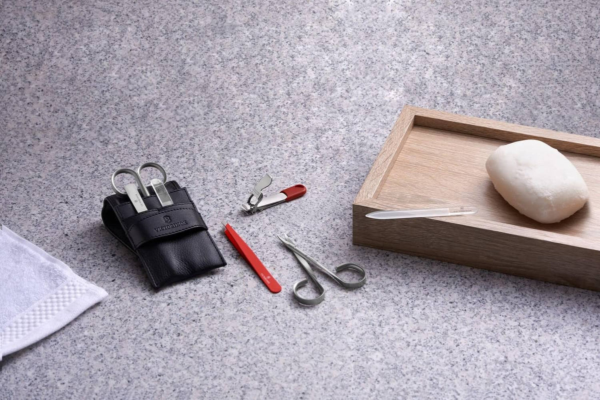 Red-handled nail clipper among small grooming tools and organizers