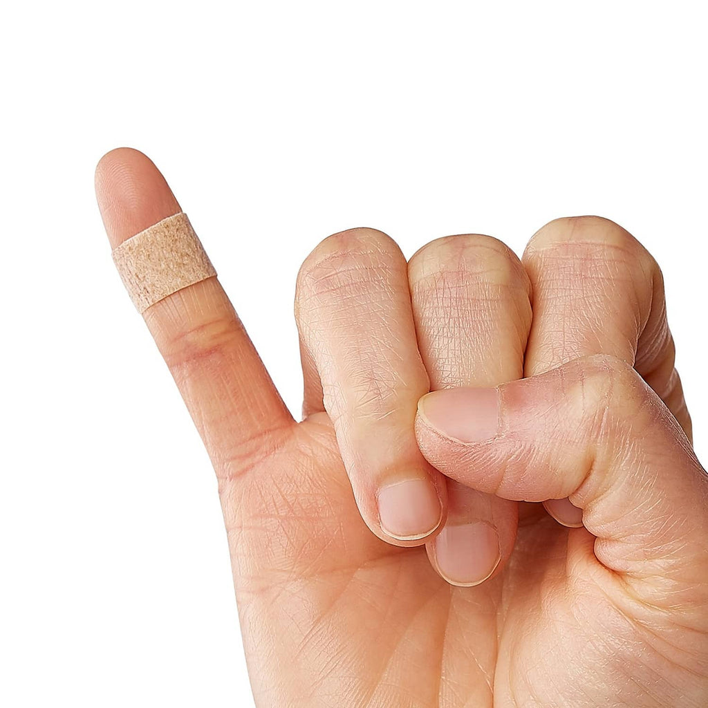 Flex-fabric bandage strip held in fingers, tan fabric with white pad
