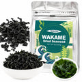 Dried wakame seaweed pouch with a pile of black seaweed and a bowl of rehydrated greens