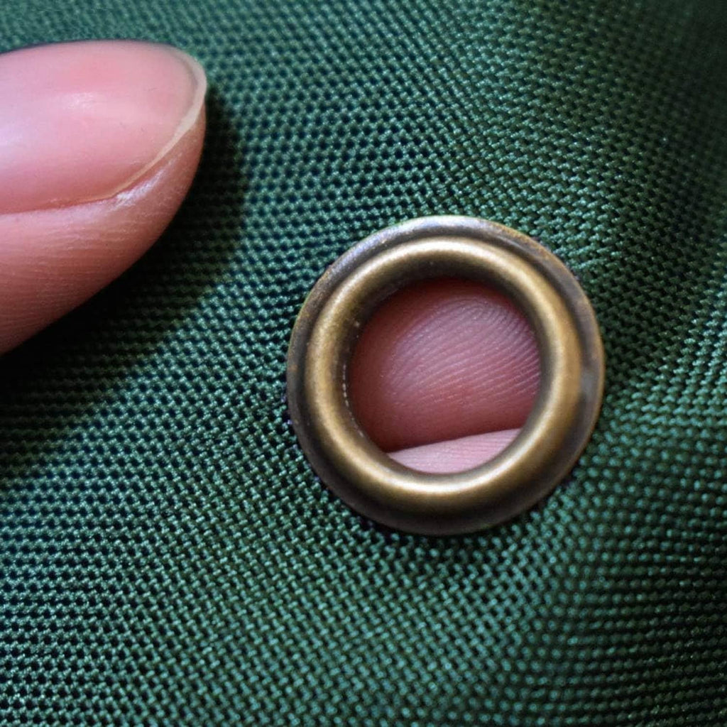 Metal grommet on dark teal grill cover fabric for securing and fastening