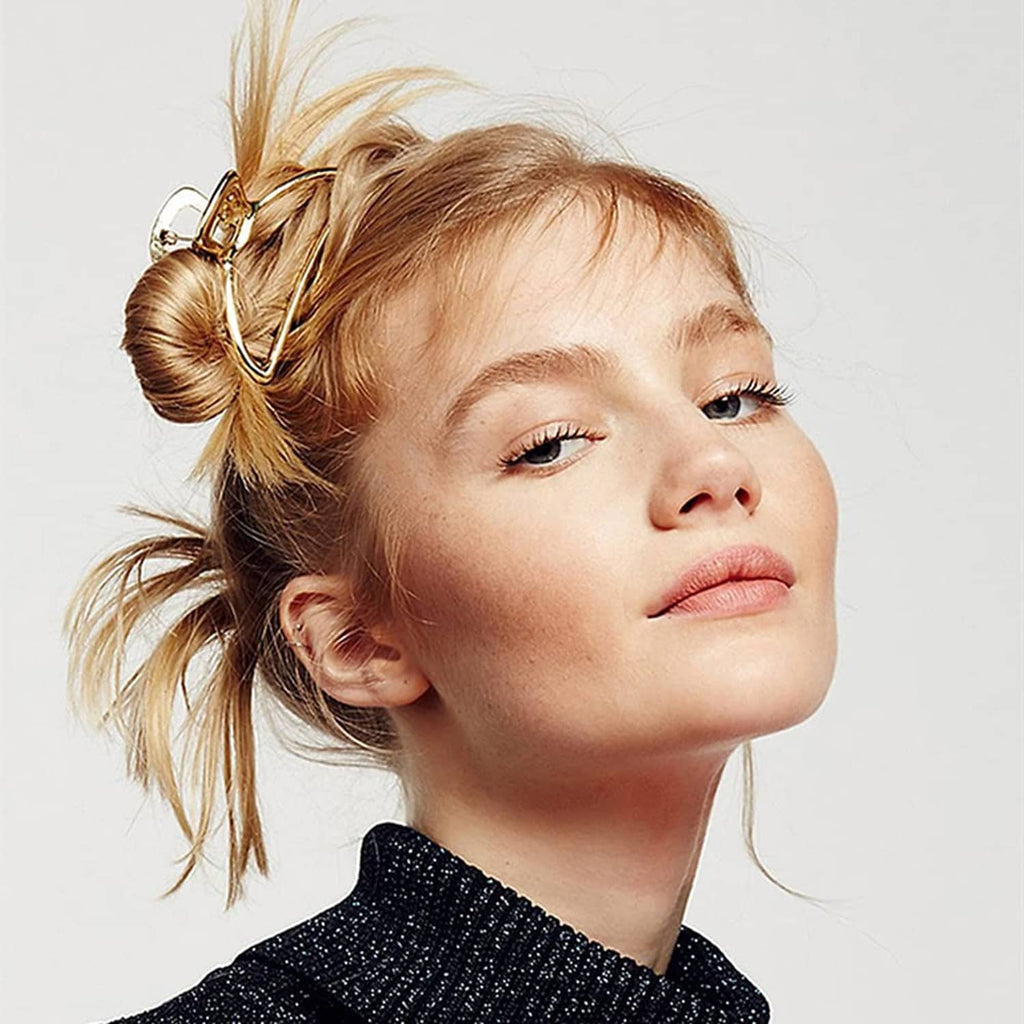 Gold metal hair claw clip on blonde ponytail, triangular frame with ridged teeth