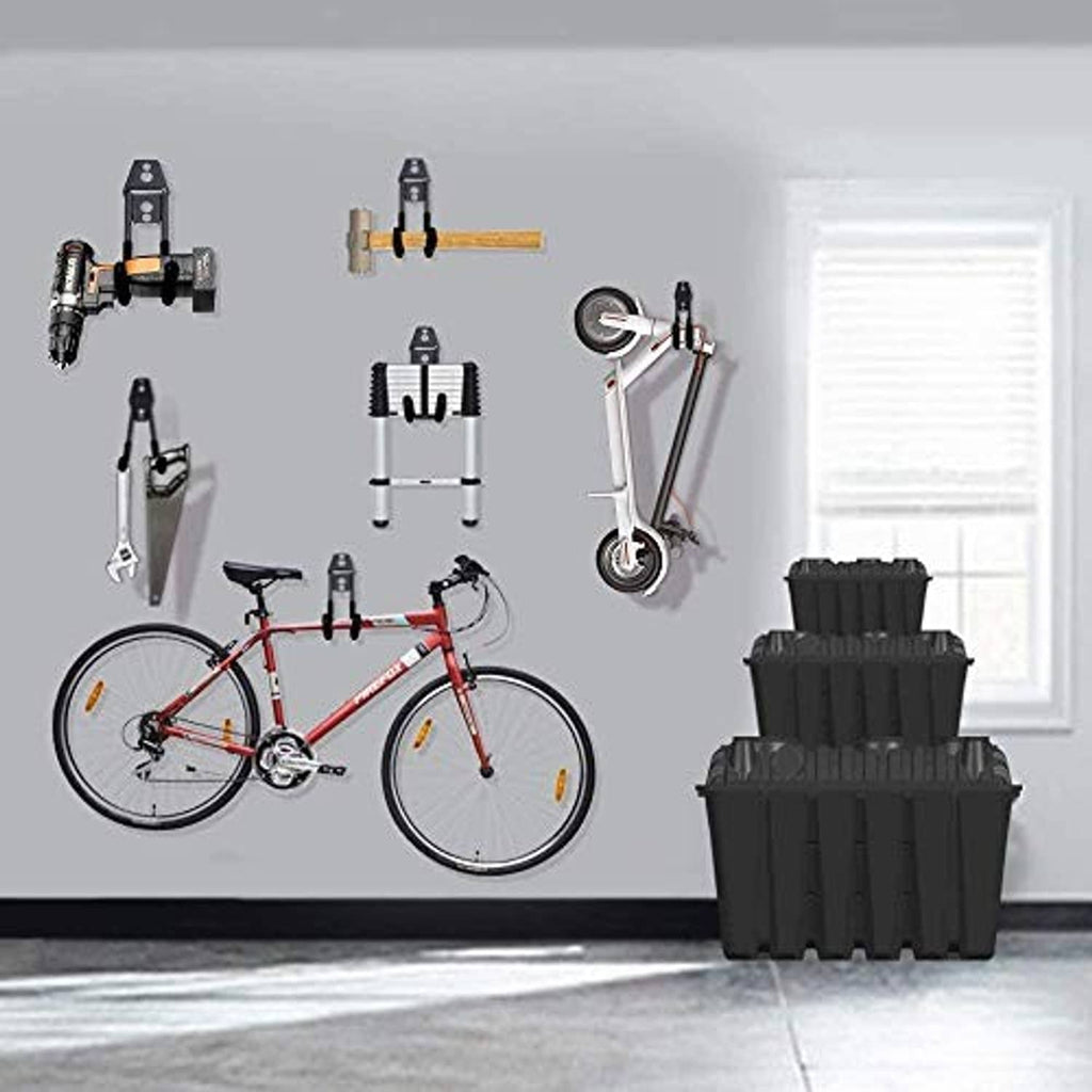 Black garage wall hooks holding various tools and accessories, arranged on the wall