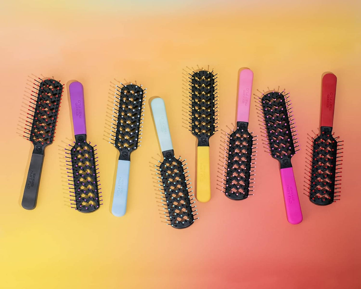 Assorted vented hair brushes lined up with black bristle heads and colorful handles