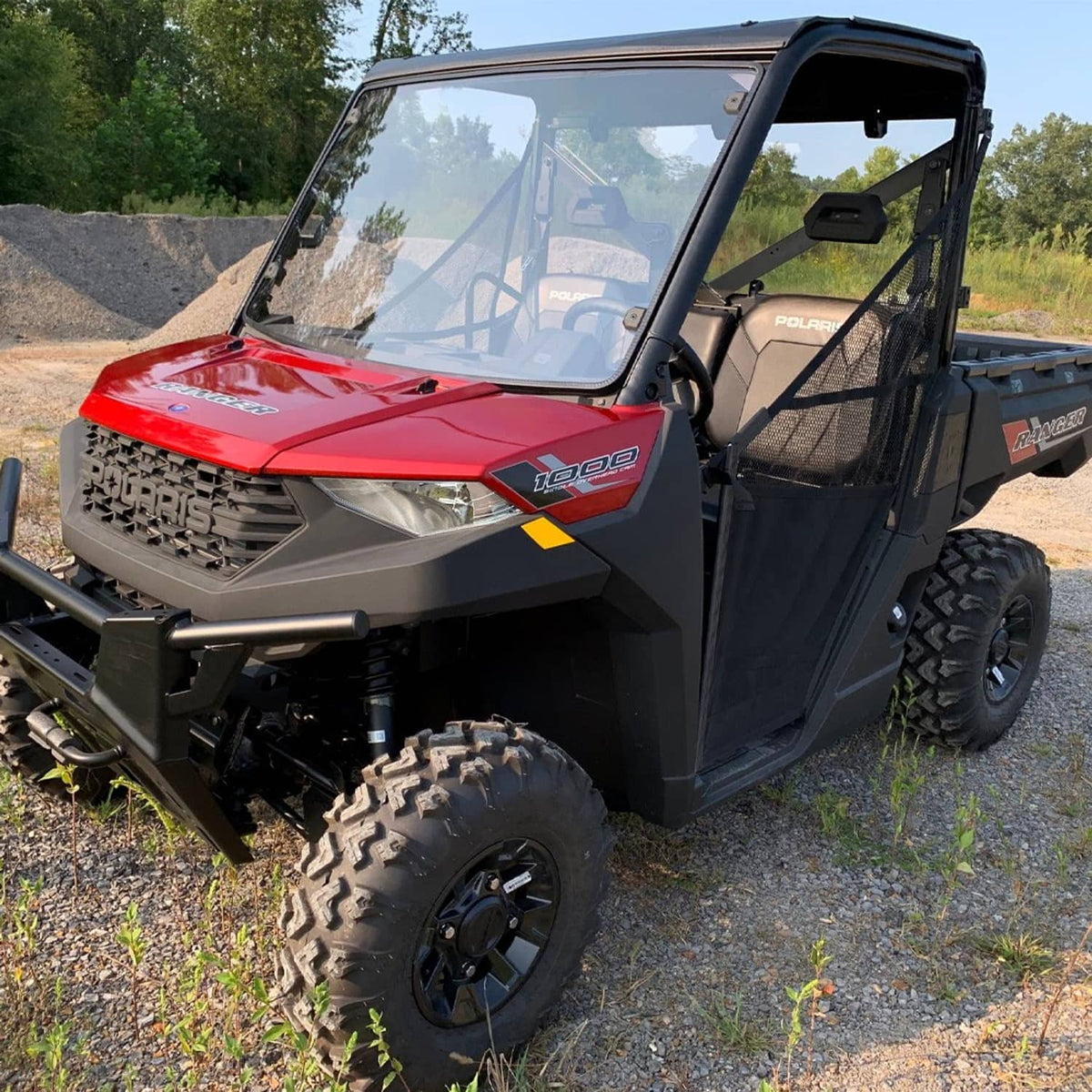 Clear front windshield mounted on UTV cab with black side panels
