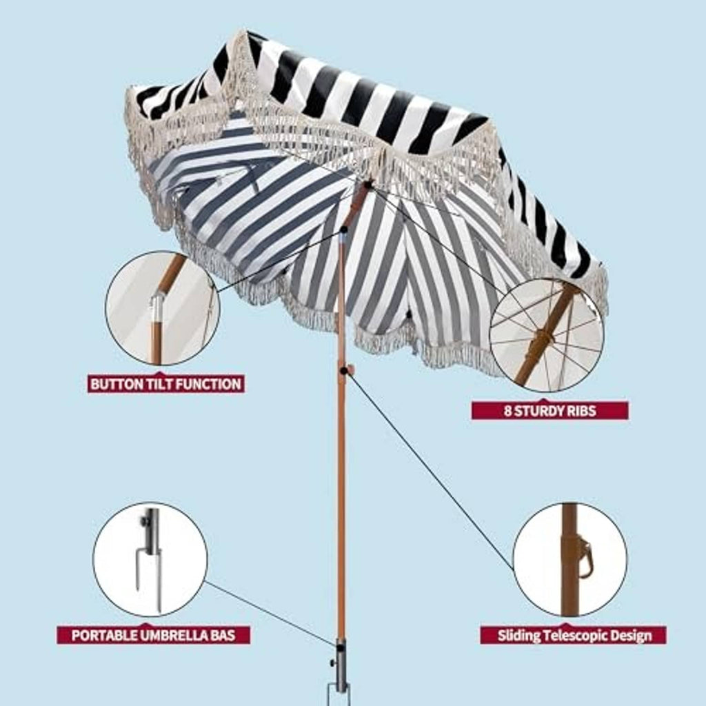 Black-and-white striped patio umbrella with white tassel fringe and wooden pole