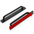 Black self-stick cabinet handle with flat rectangular base and curved bar grip