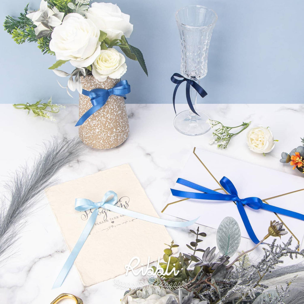 Decorative blue satin ribbon bows and ribbon ties on gift items and envelopes