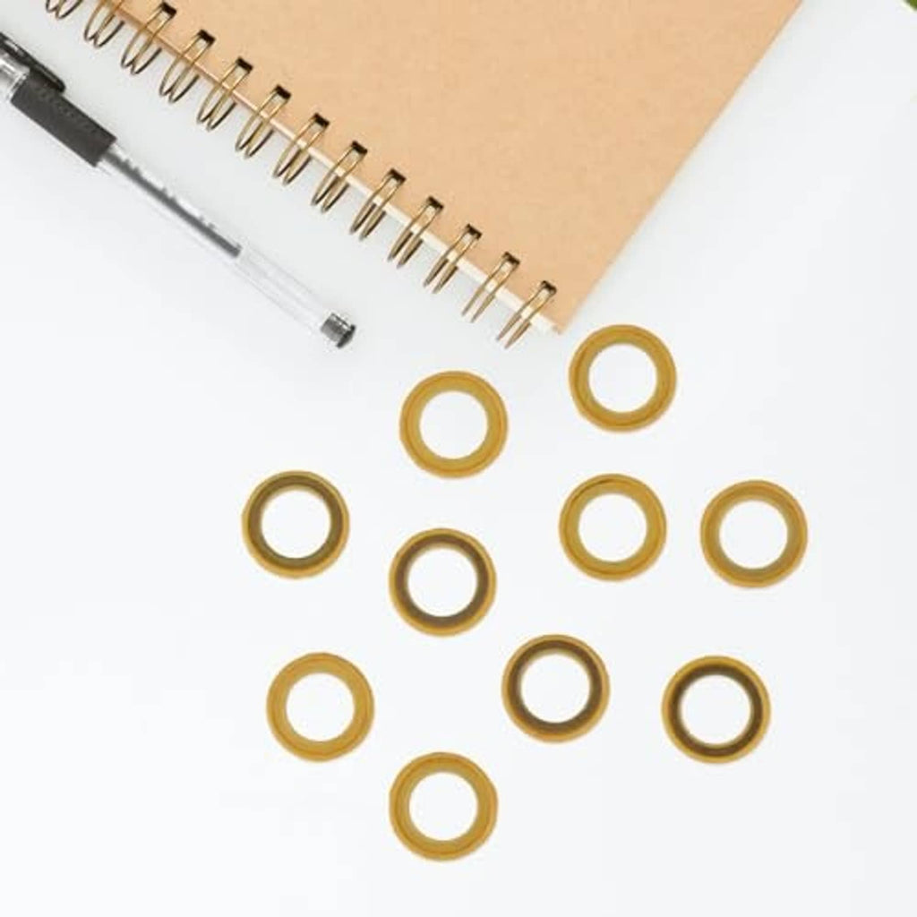 Loose assortment of yellow round drain plug seal gasket rings on paper