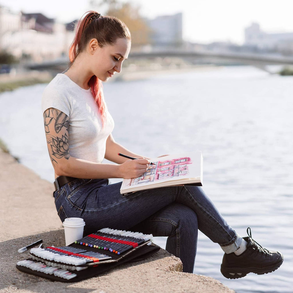 Black marker pen organizer case on person’s lap, open with rows of markers in slots