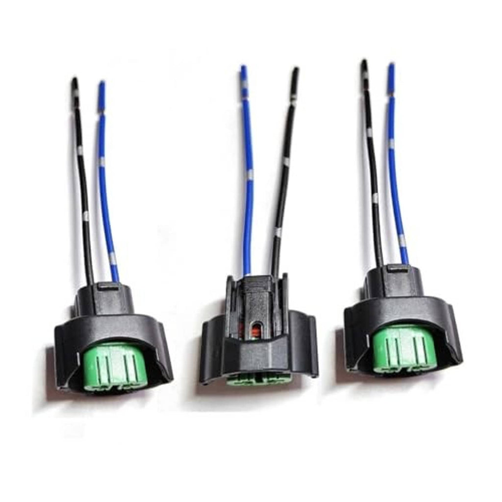 Three headlight bulb adapter plugs with green sockets, black housings, blue/black wiring