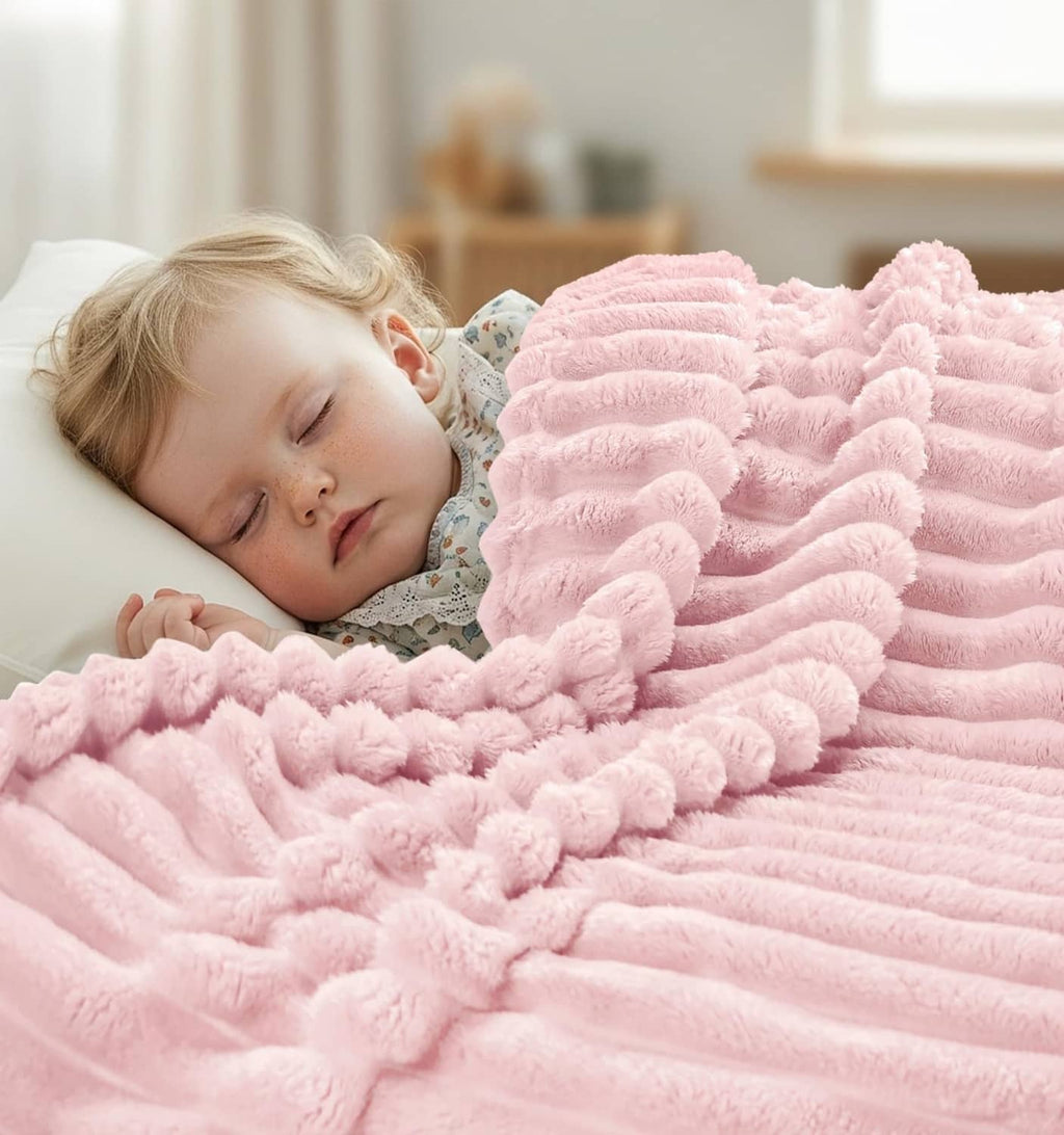 Pink plush fleece blanket tucked on a child's bed for cozy coverage