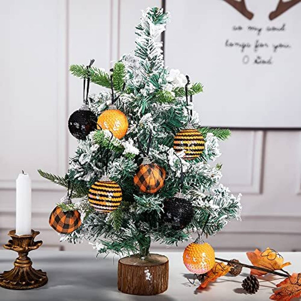 Sequin hanging ball ornaments in black and orange on green garland for Halloween decor
