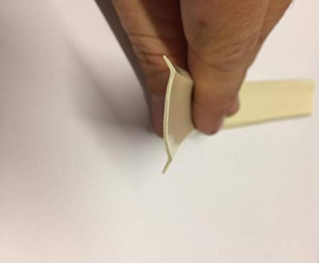 Hand smoothing a light tan vinyl trim edge on a flat surface