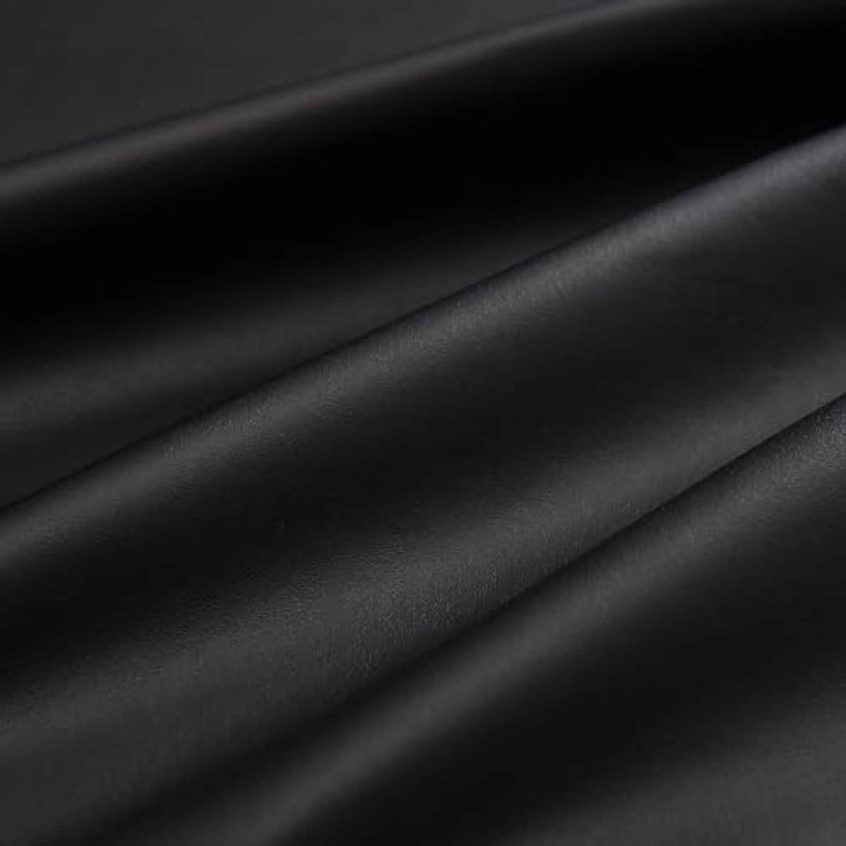 Close-up of black PU vinyl leather texture with smooth, matte surface grain