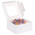 White square bakery cake box with open lid, holding colorful cupcakes inside.