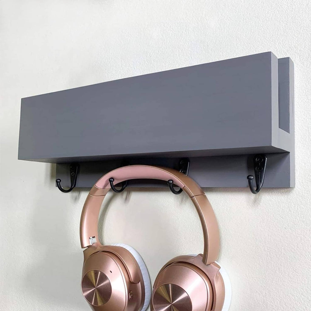 Black coat hooks fixed under shelf, showing four ring hooks mounted on wall