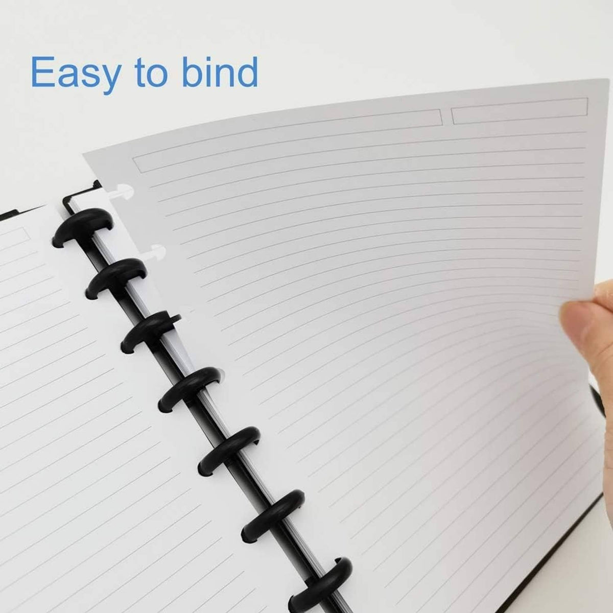 White lined disc refill paper sheet clipped onto black ring binder