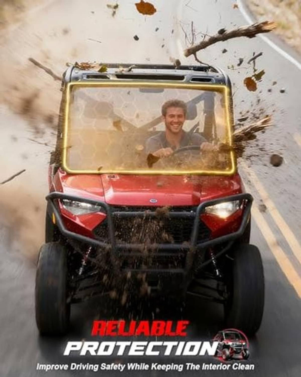 UTV windshield with clear front panel and dark frame, driving through dust and debris