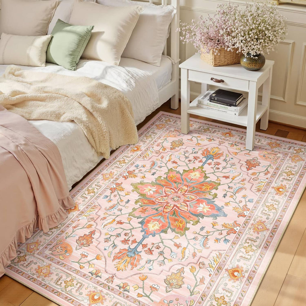 Rectangular area rug with pastel pink, orange, and blue vintage floral medallion pattern