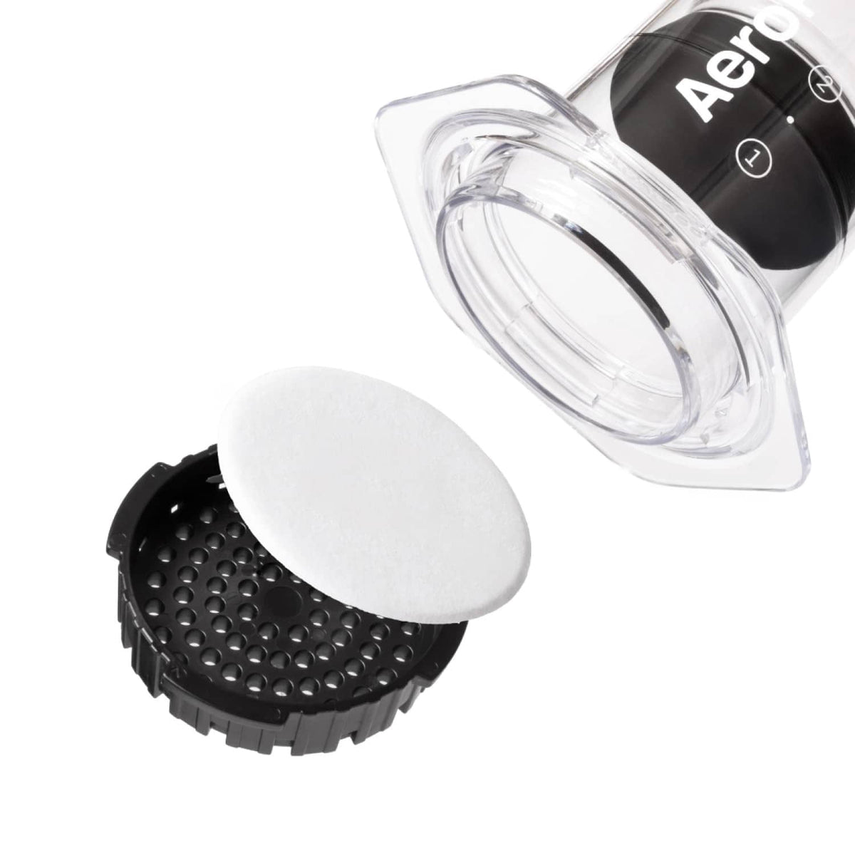 White AeroPress filter disc on a black perforated base