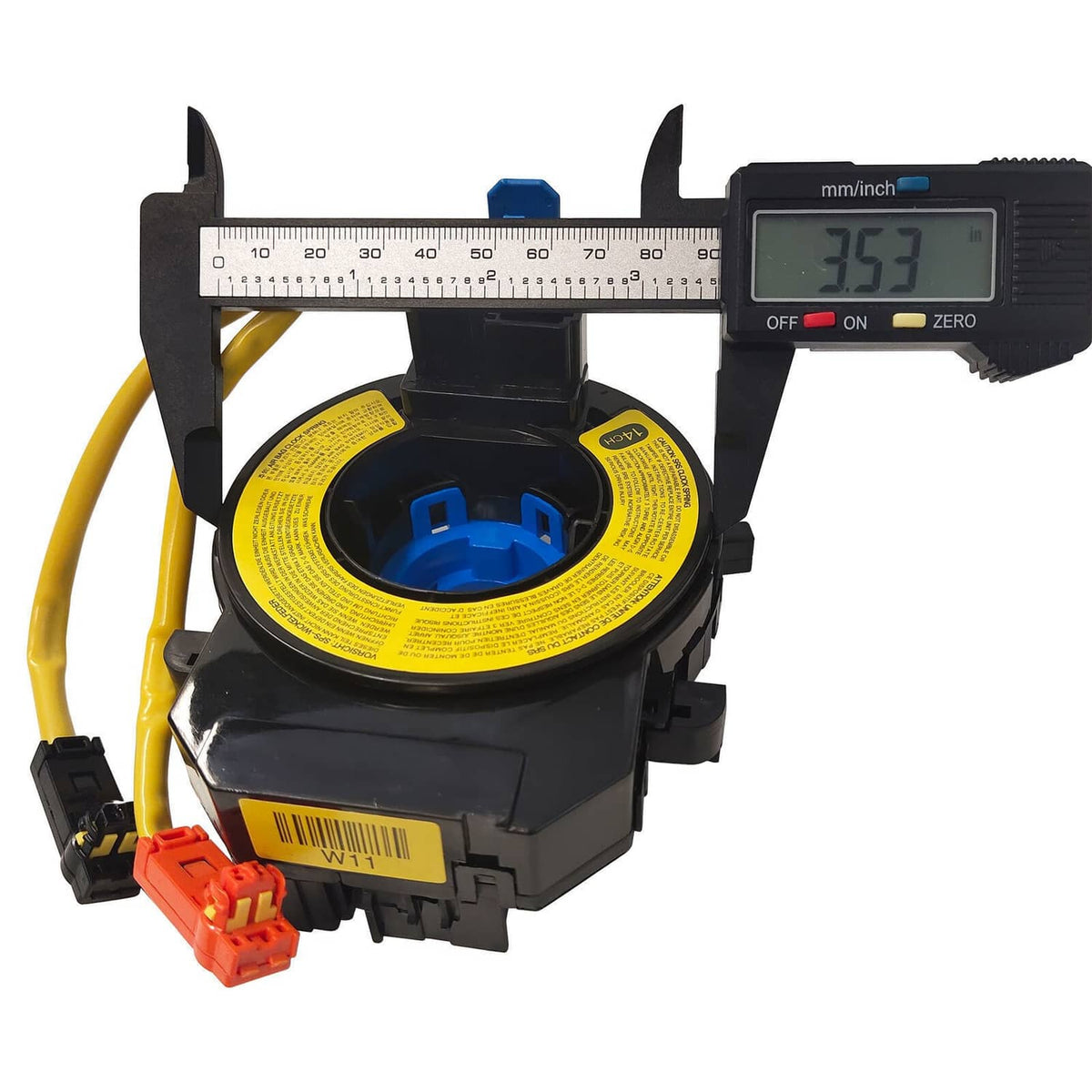 Clock spring spiral cable shown with measuring calipers over yellow warning label