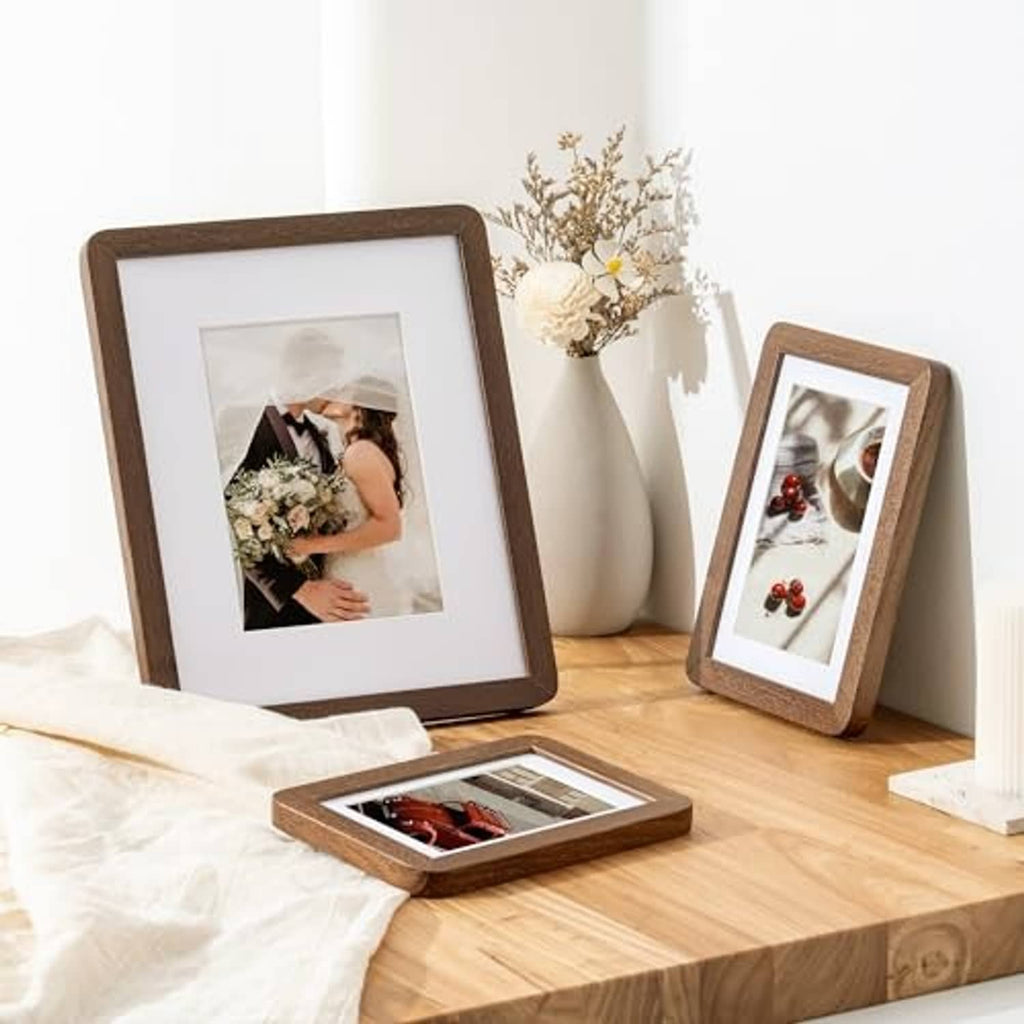 Tabletop display of dark oak photo frames with white mats and backing
