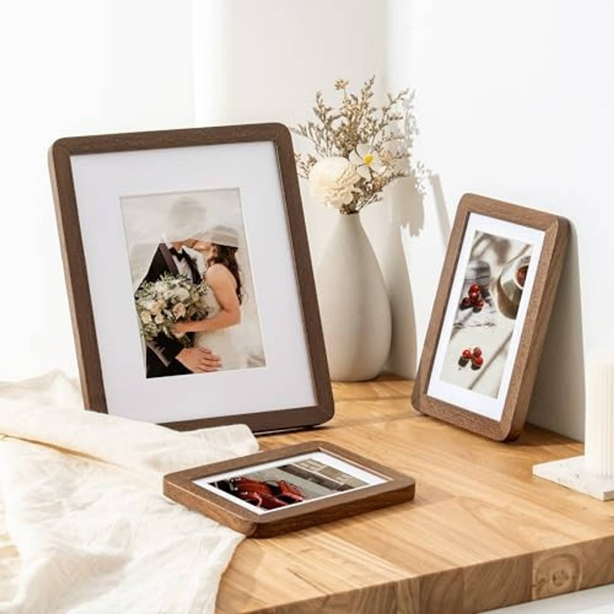 Tabletop display of dark oak photo frames with white mats and backing