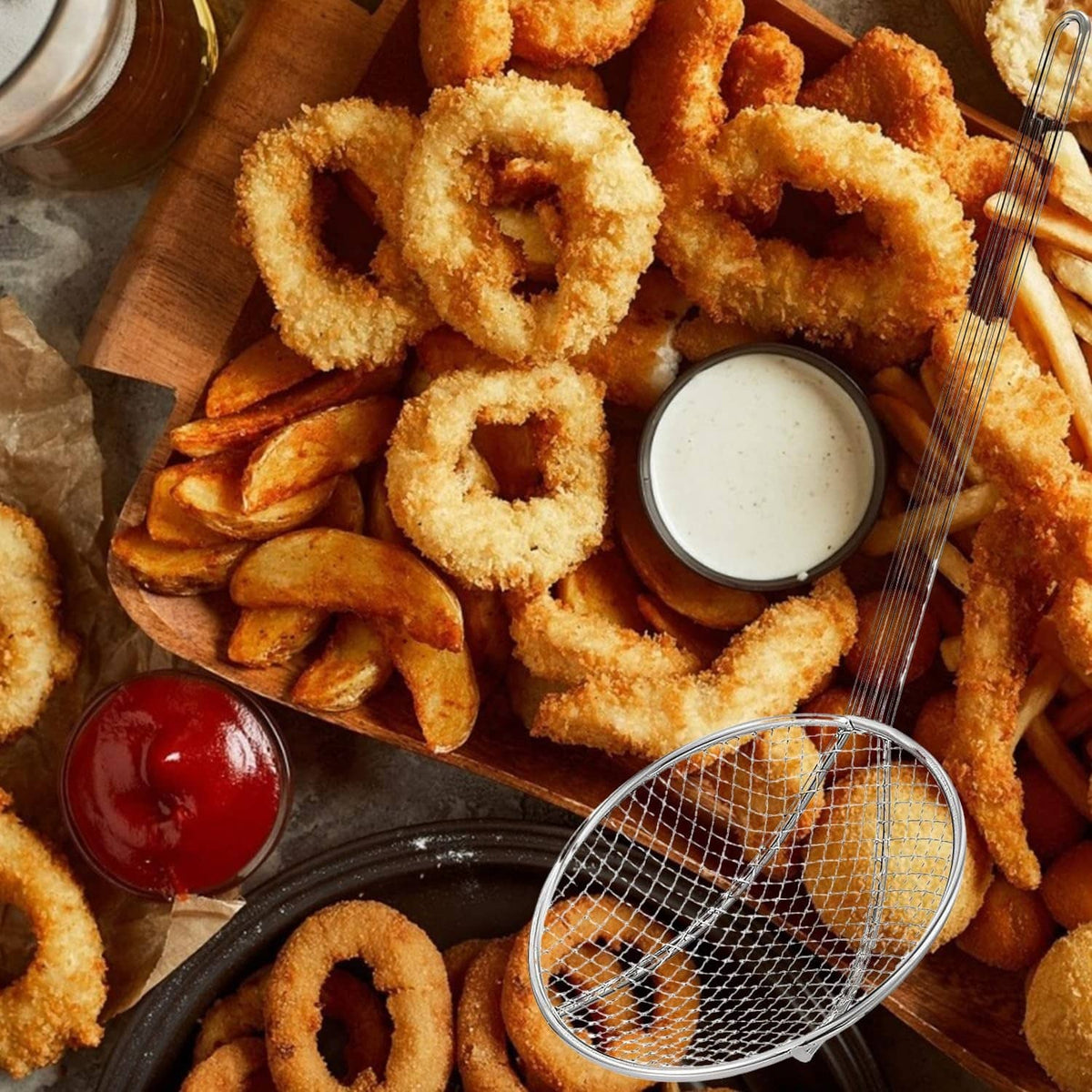 Round mesh fryer skimmer lifting fried food from a tray