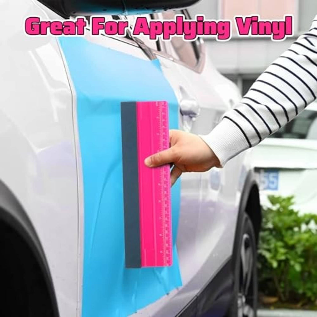 Pink vinyl wrap squeegee with dark felt edge and measuring scale along the blade
