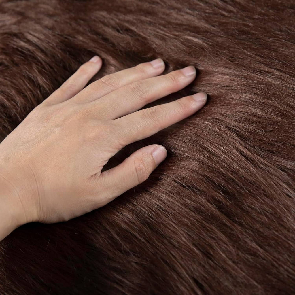 Brown faux fur fabric with hand pressing the plush pile for softness detail.
