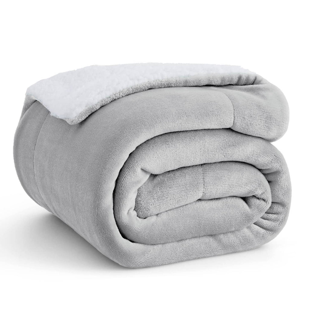 Light grey sherpa fleece throw blanket, folded with soft textured lining visible