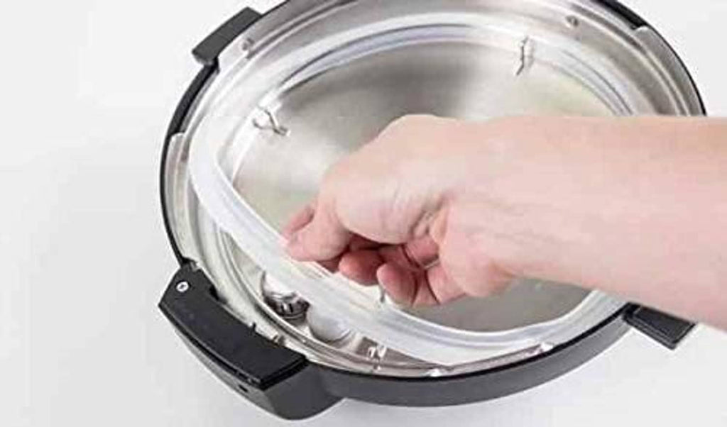 Hand installing clear rubber gasket on stainless lid rim
